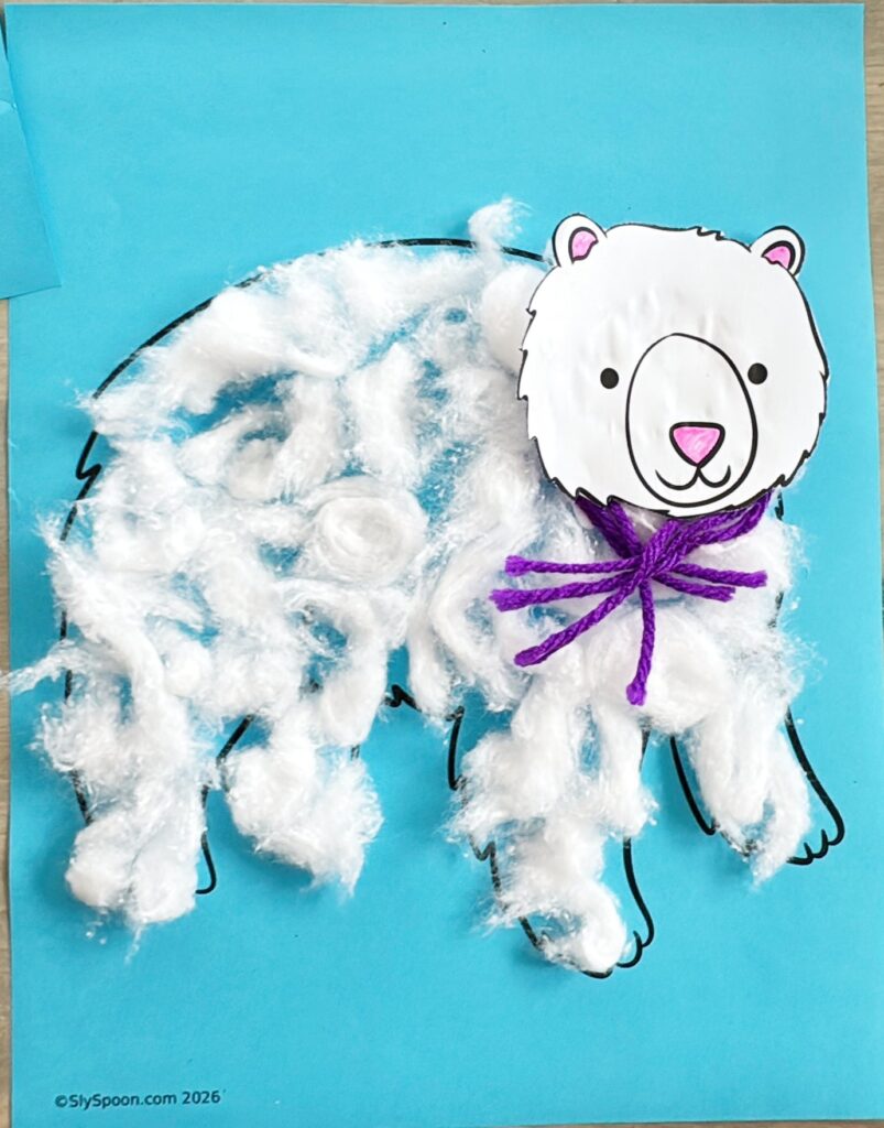 Completed polar bear winter craft made with cotton balls, blue paper, and printable templates, suitable for preschool and kindergarten.