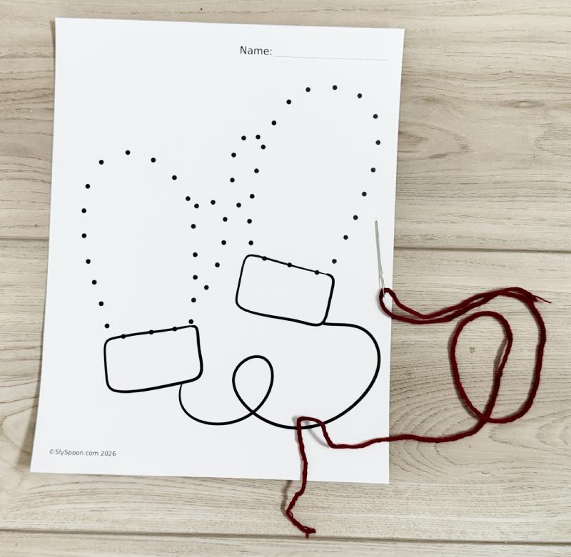 Mitten sewing winter craft made with cardstock paper, yarn, and printable templates, suitable for preschool and kindergarten.