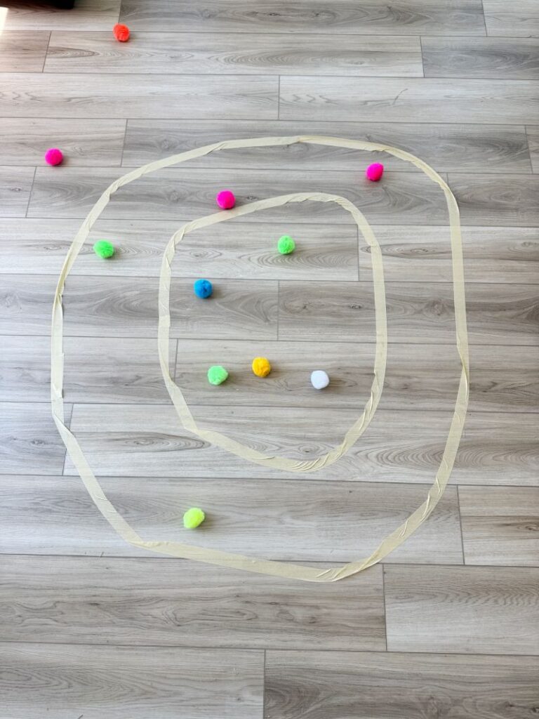 Letter O Pom Pom toss game with a letter O made of masking tape