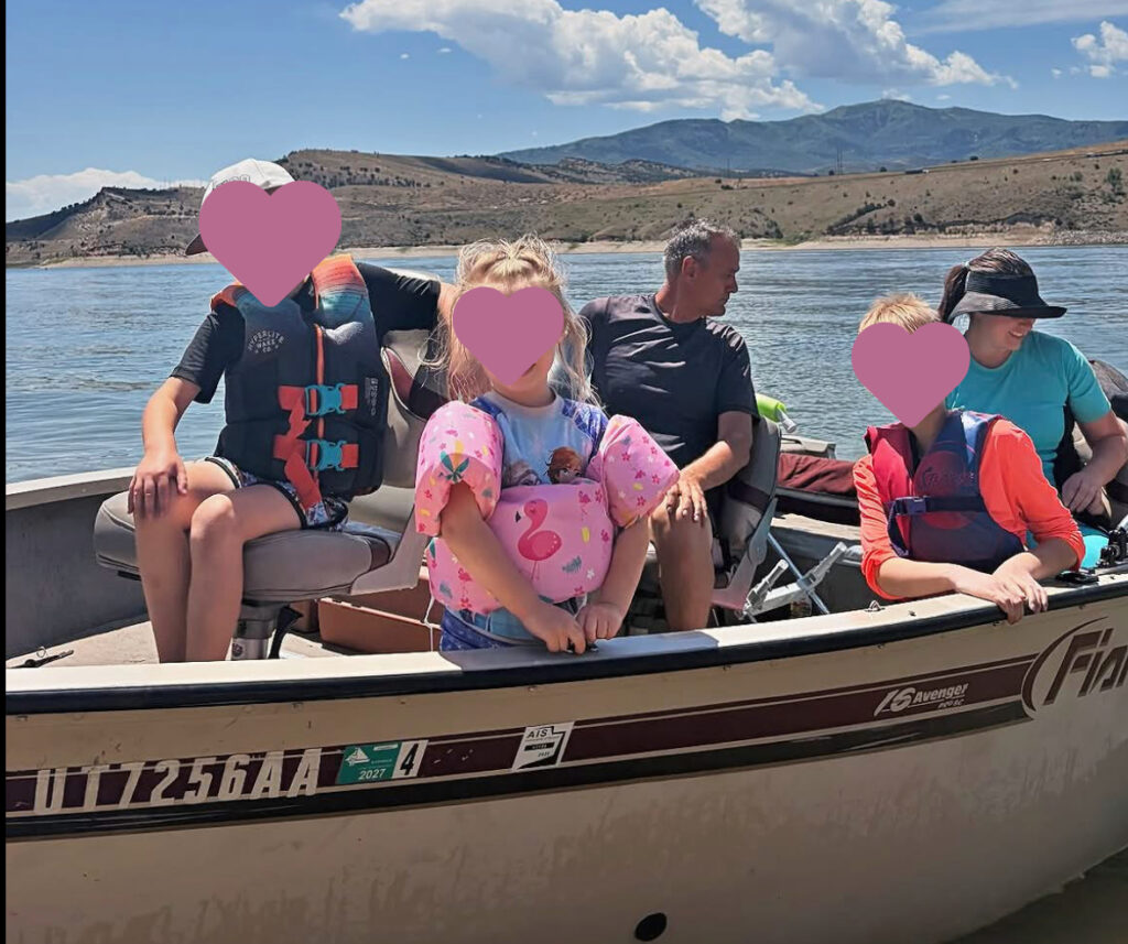 Mom wearing a short sleeve rash guard with built-in bra while enjoying a family day on the boat.
