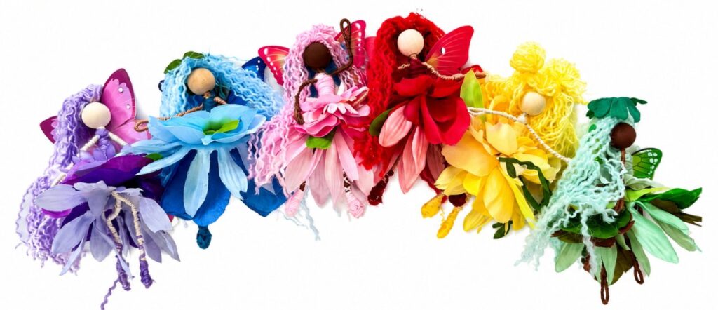 line up of fiber art flower petal flower fairies in a rainbow of colors