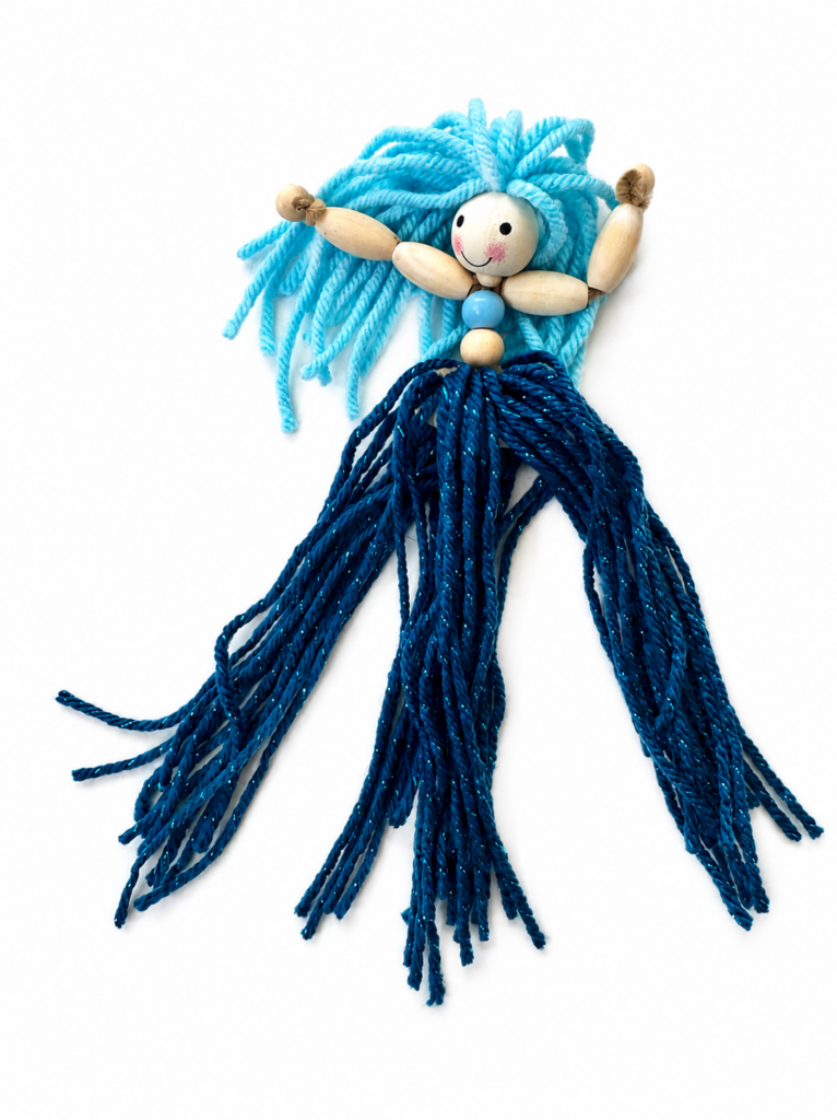 Three sections of yarn being braided to create the tail of a handmade mermaid doll.