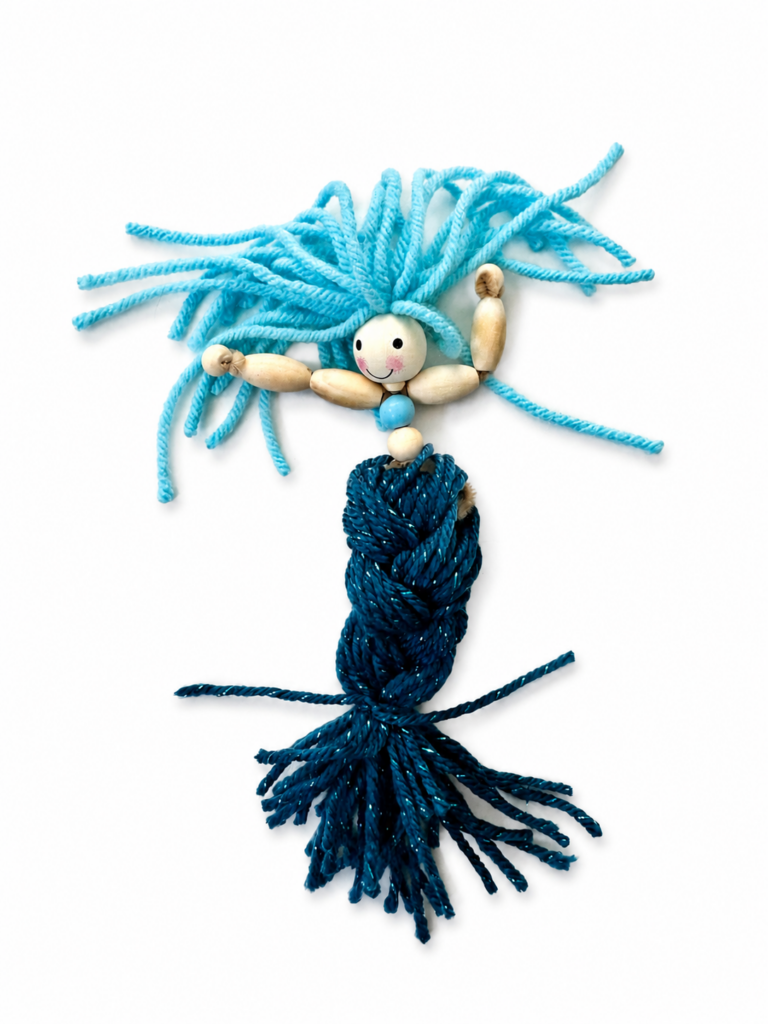 Three sections of yarn being braided to create the tail of a handmade mermaid doll.