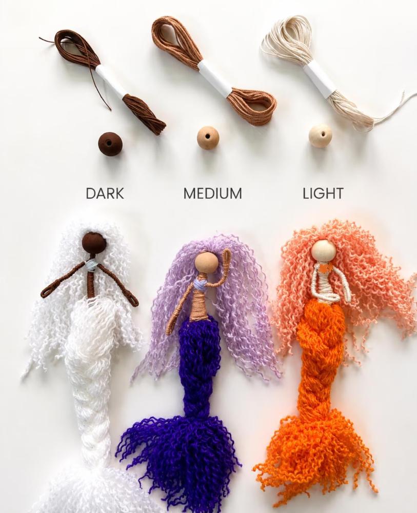 Fiber art mermaids showing how different colored wooden beads and string can make different colored mermaids.