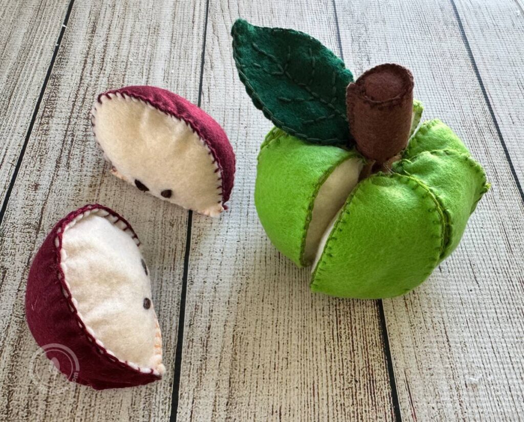 Finished green apple with stem and leaves and finished red apple slices
