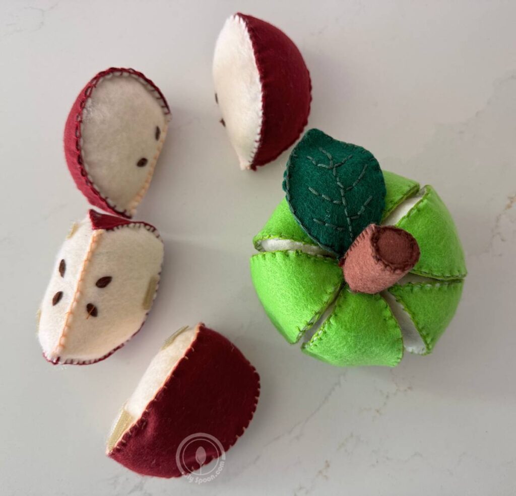 Finished green apple with stem and leaves and finished red apple slices